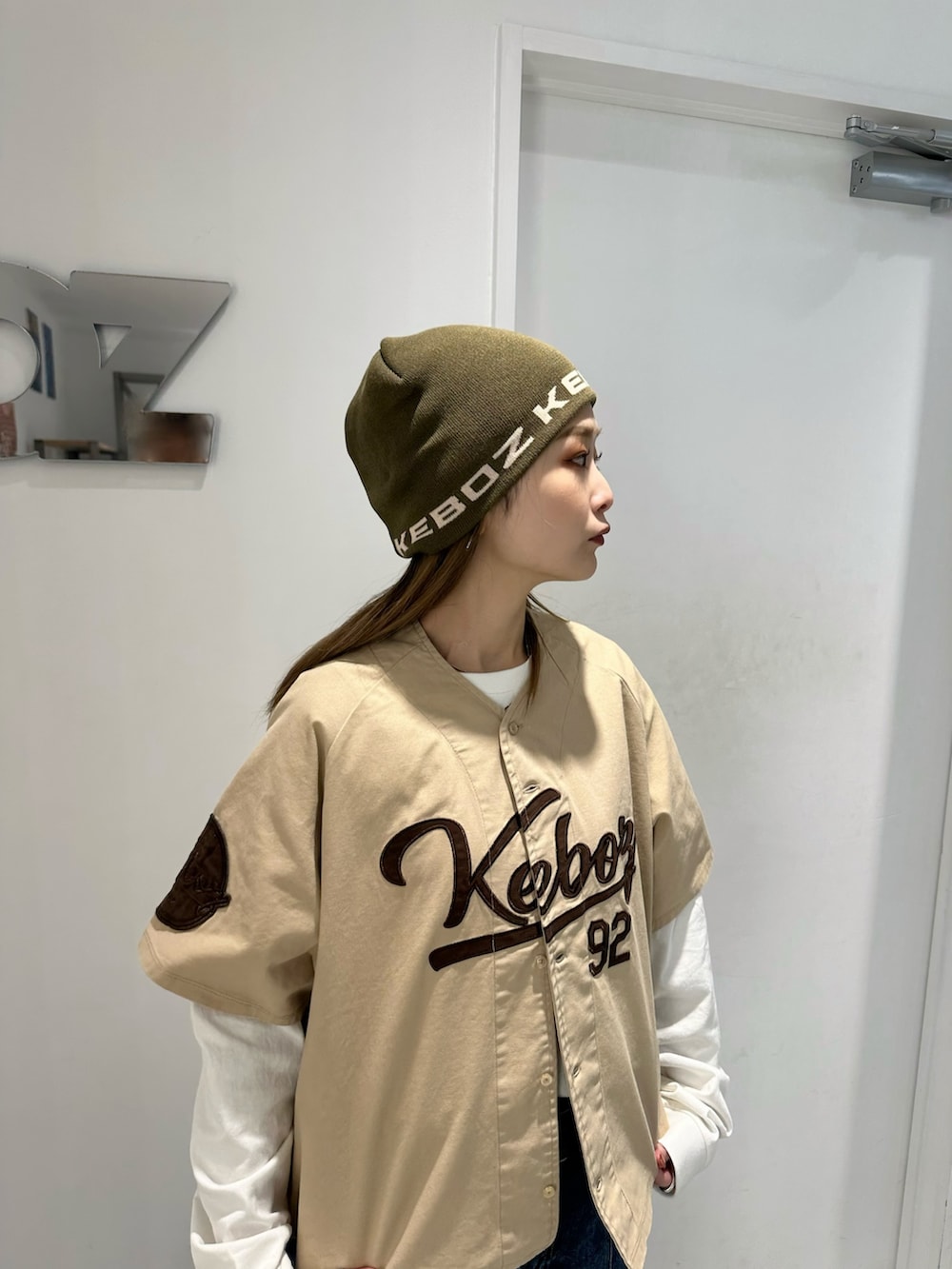 ベージュ系のシャツ/ブラウス、ホワイト系のTシャツ/カットソー、ブルー系のデニムスカートを着用したレディースの秋コーディネートの3枚目の写真