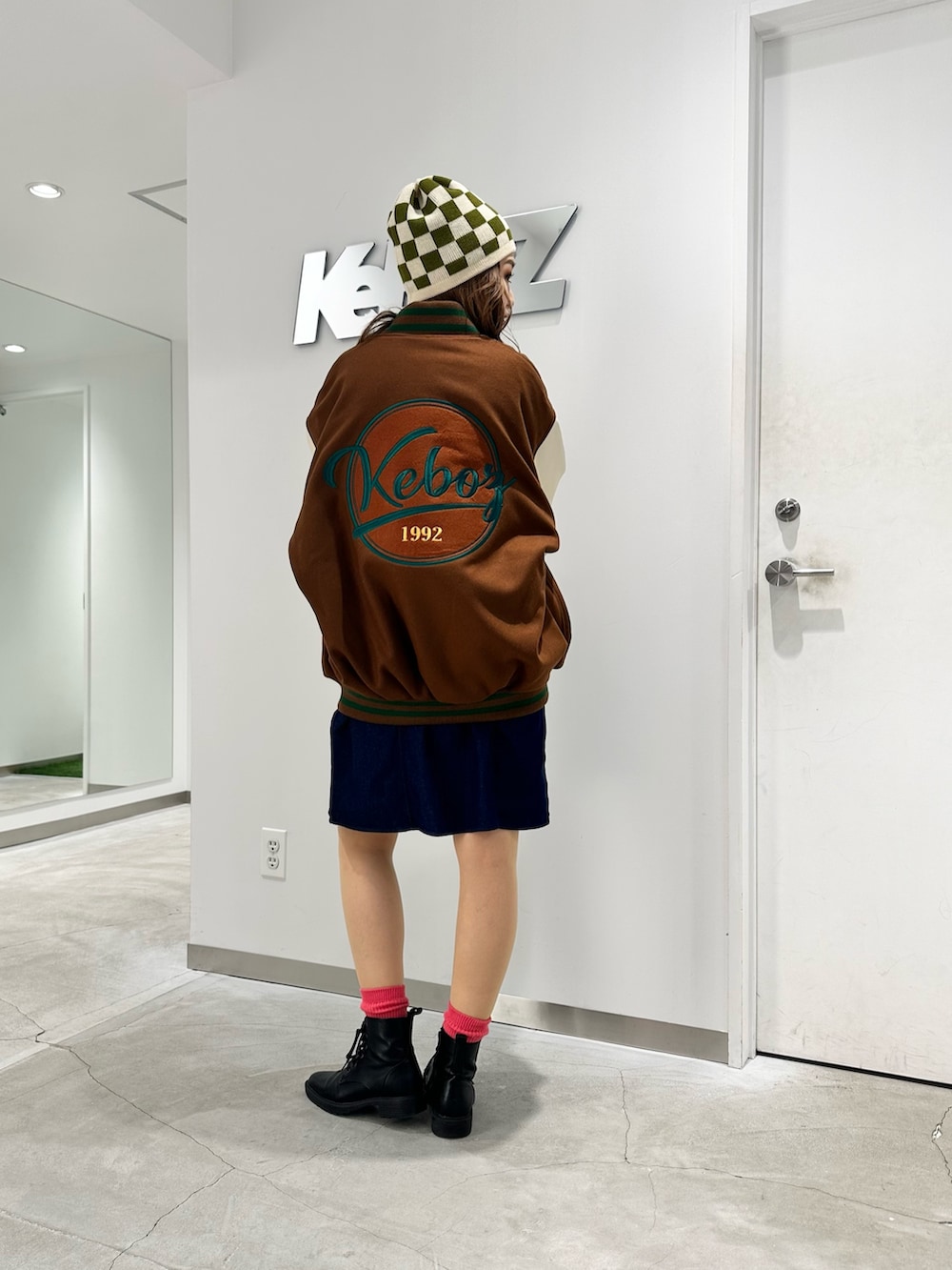 ブラウン系のスタジャン、ブルー系のシャツワンピース、ベージュ系のニットキャップ/ビーニーを着用したレディースの秋コーディネートの2枚目の写真