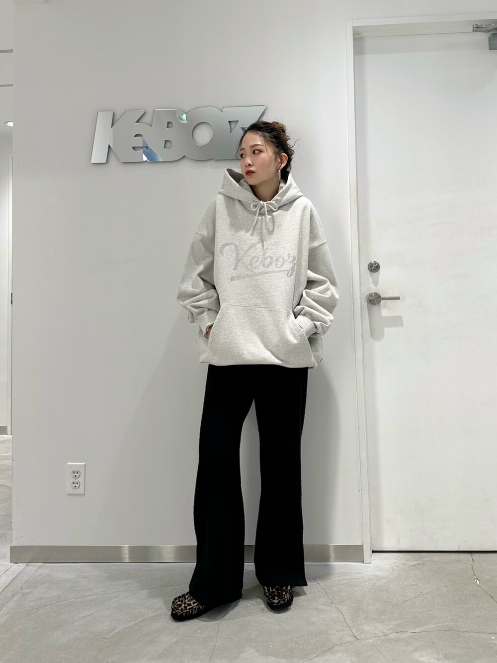 グレー系のパーカー、ブラック系のその他パンツを着用したレディースの冬コーディネートの2枚目の写真