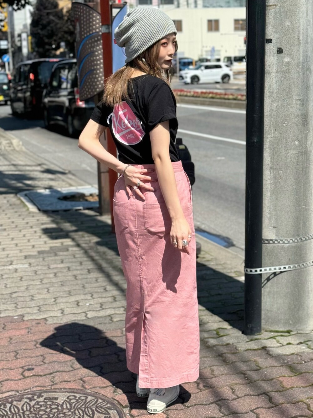 ピンク系のスカート、ブラック系のTシャツ/カットソーを着用したレディースの秋コーディネートの2枚目の写真