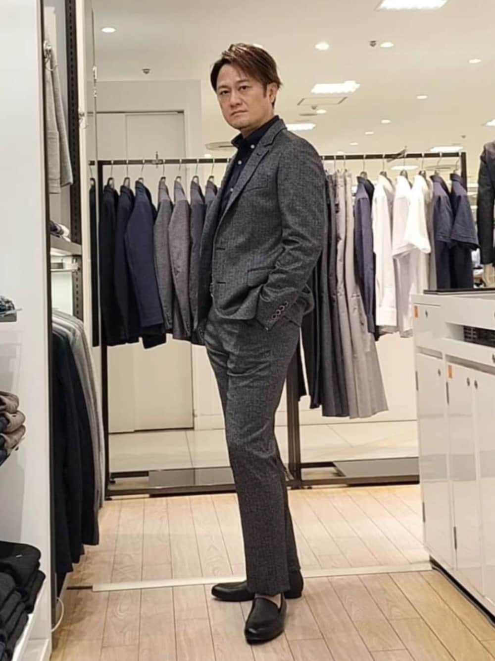 ブラック系のその他アウター、ブラック系のスーツパンツ、ブルー系のシャツ/ブラウスを着用したメンズの秋コーディネートの3枚目の写真