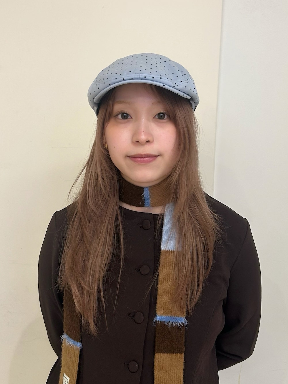 ブラウン系のトップス、ブルー系のデニムパンツ、ブルー系のハンチング/ベレー帽を着用したレディースの春コーディネートの2枚目の写真
