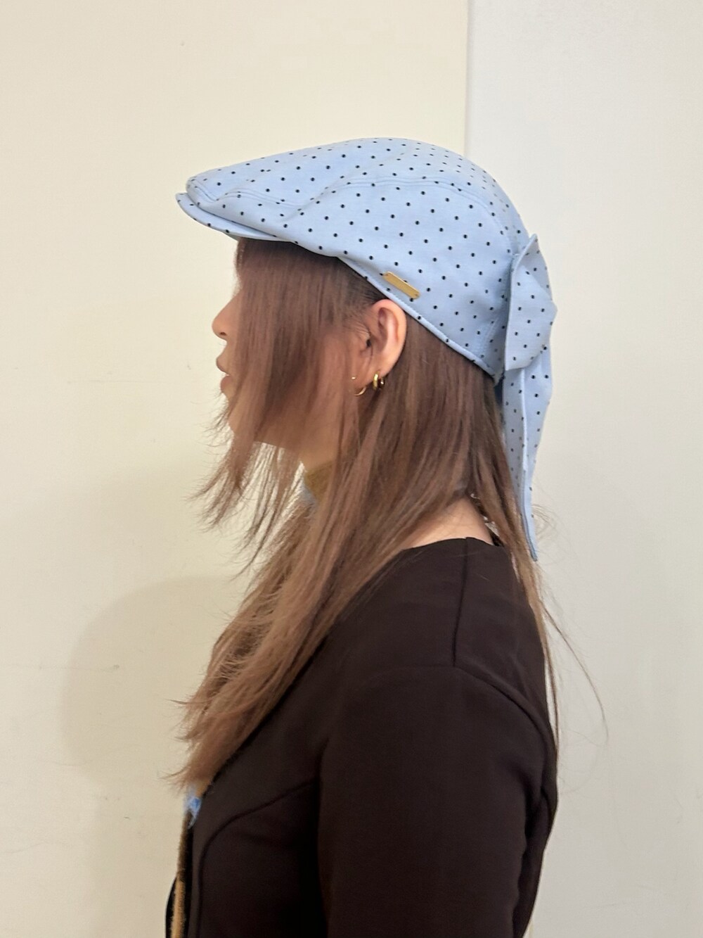 ブラウン系のトップス、ブルー系のデニムパンツ、ブルー系のハンチング/ベレー帽を着用したレディースの春コーディネートの3枚目の写真