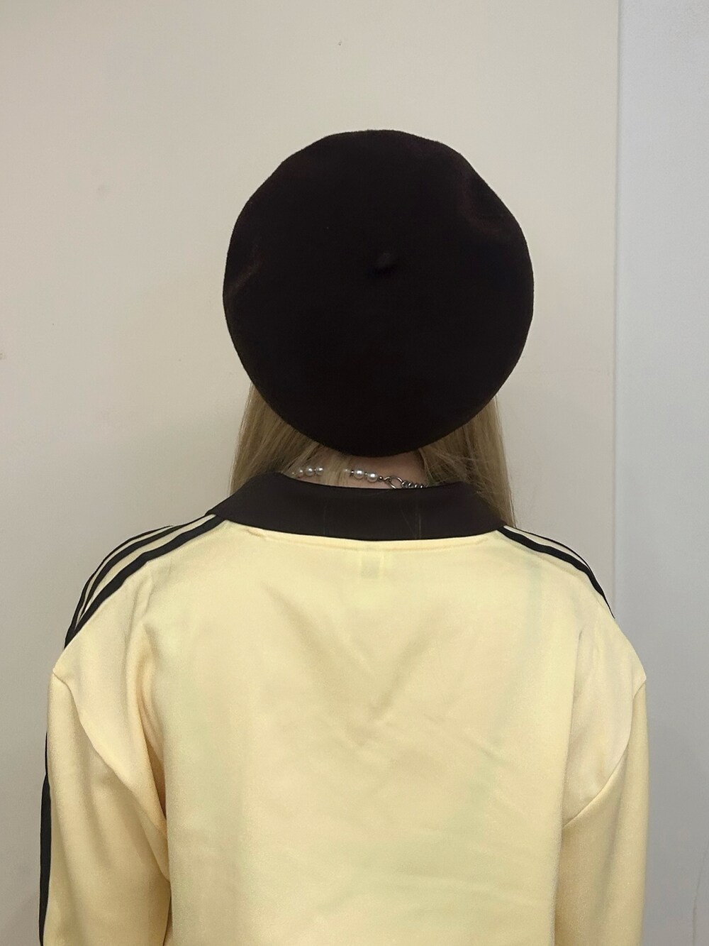 イエロー系のトップス、ベージュ系のスカート、ブルー系のスニーカーを着用したレディースの秋コーディネートの4枚目の写真