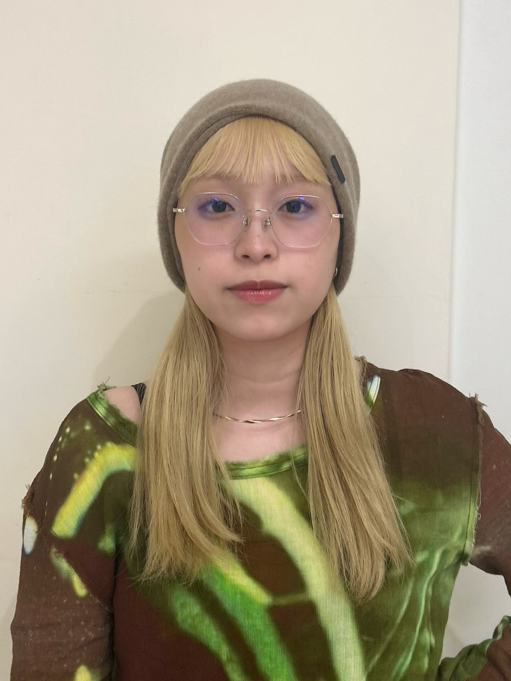 ブラウン系のトップス、ベージュ系のスカート、ブルー系のスニーカーを着用したレディースの秋コーディネートの2枚目の写真