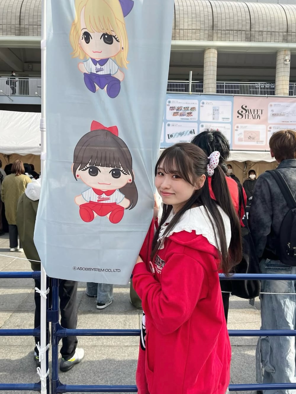 グレー系のスカート、レッド系のパーカー、その他のその他を着用したレディースの春コーディネートの2枚目の写真