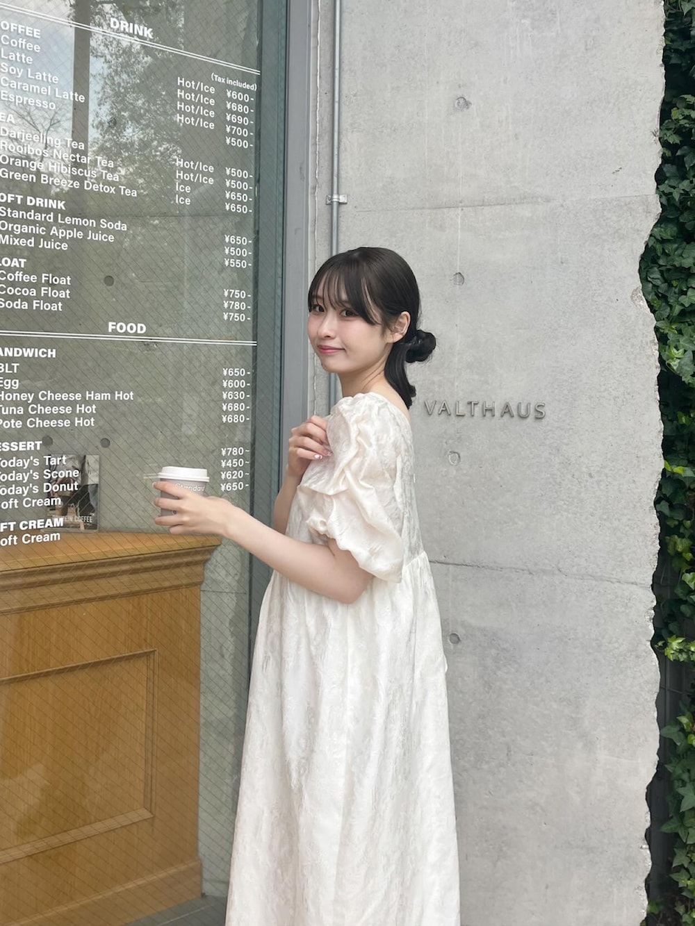 ブラウン系のブルゾン、ホワイト系のドレス、ホワイト系のスニーカーを着用したレディースの春コーディネートの2枚目の写真