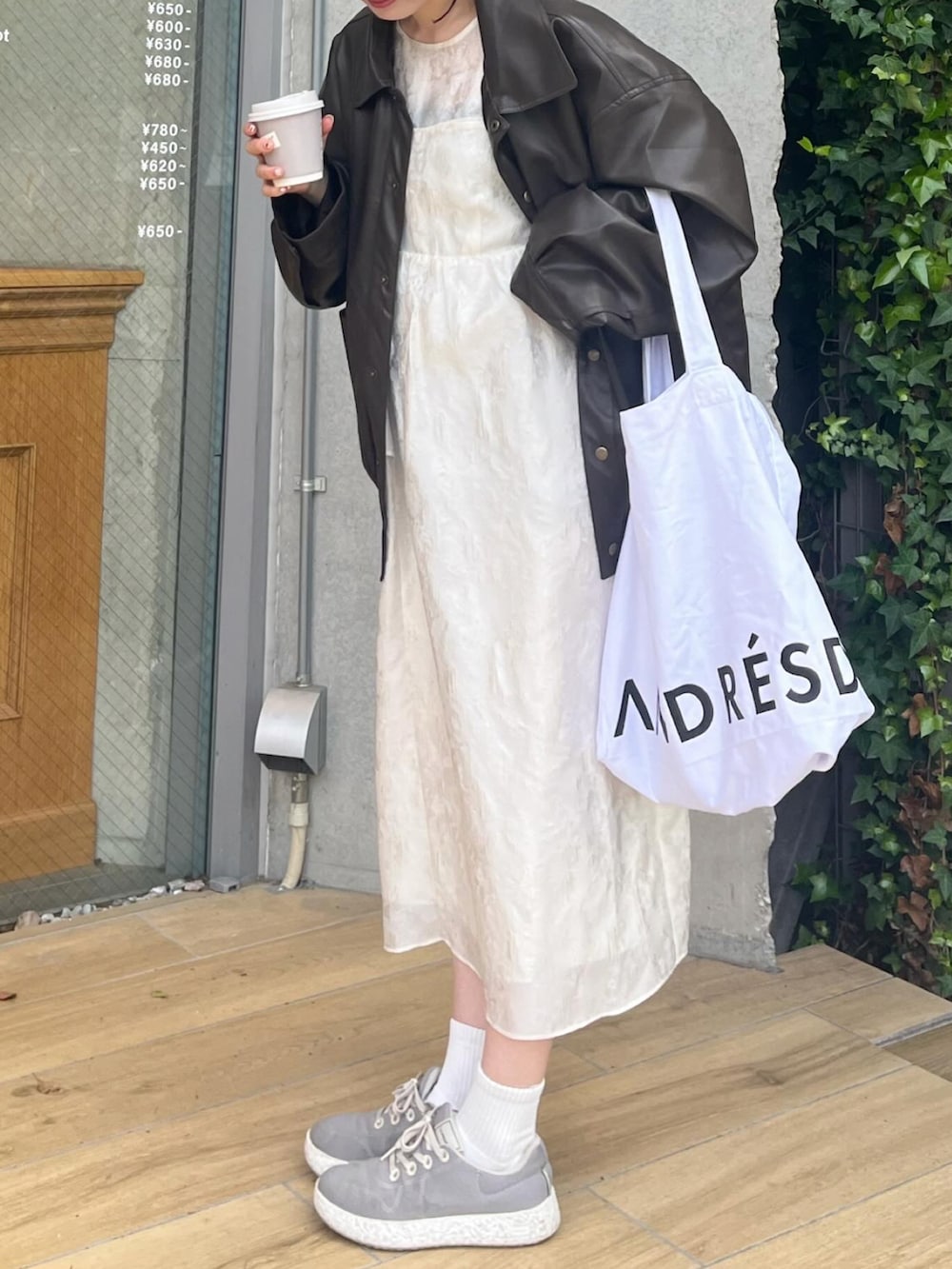 ブラウン系のブルゾン、ホワイト系のドレス、ホワイト系のスニーカーを着用したレディースの春コーディネートの3枚目の写真