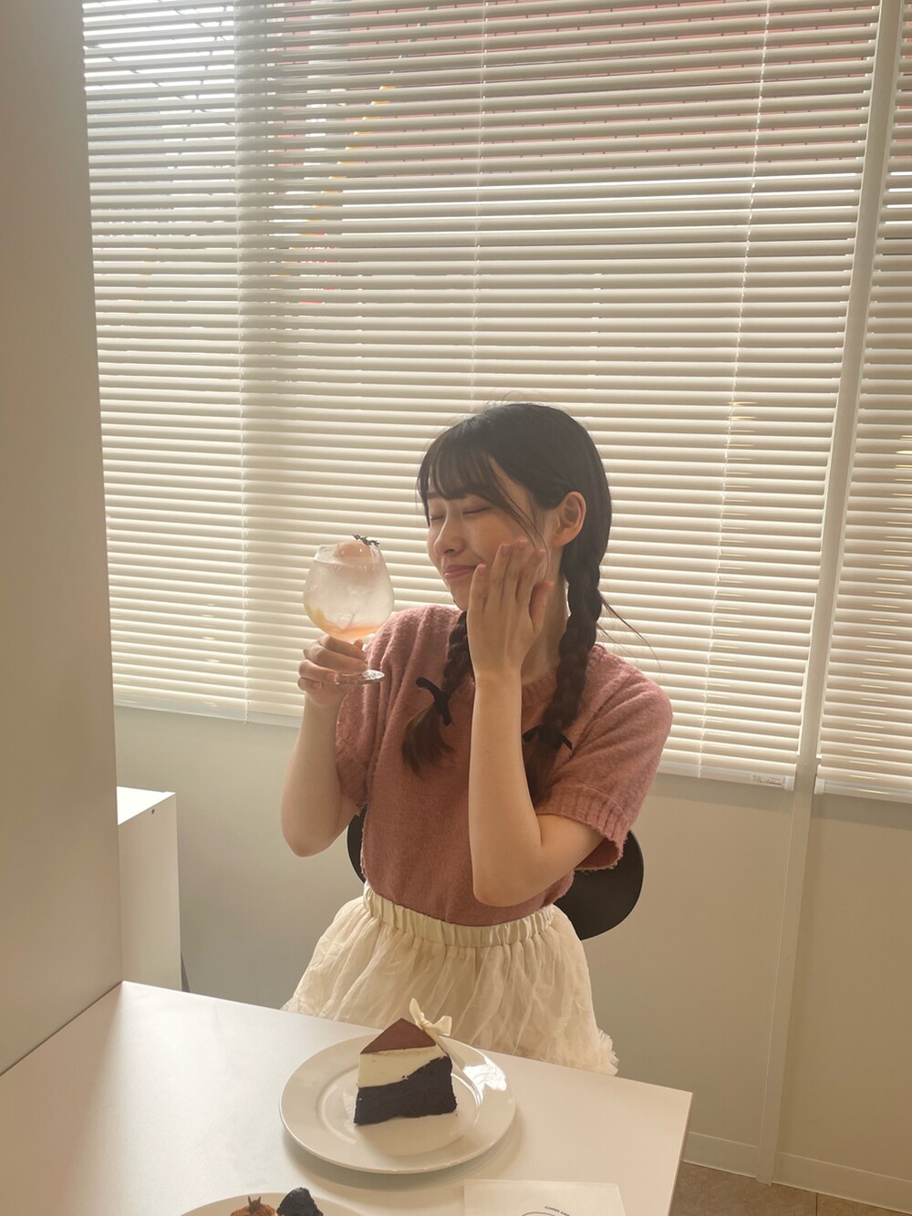 ピンク系のニット/セーター、ホワイト系のショルダーバッグ、ホワイト系のスカートを着用したレディースの夏コーディネートの3枚目の写真