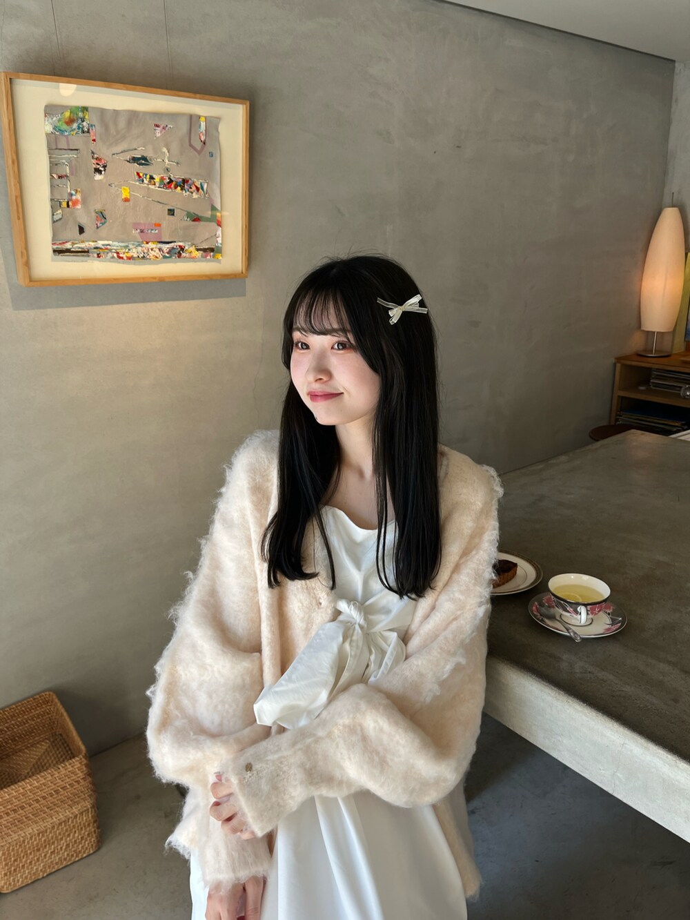 ピンク系のカーディガン/ボレロ、ホワイト系のワンピース/ドレス、ブラック系のシューズを着用したレディースの春コーディネートの3枚目の写真
