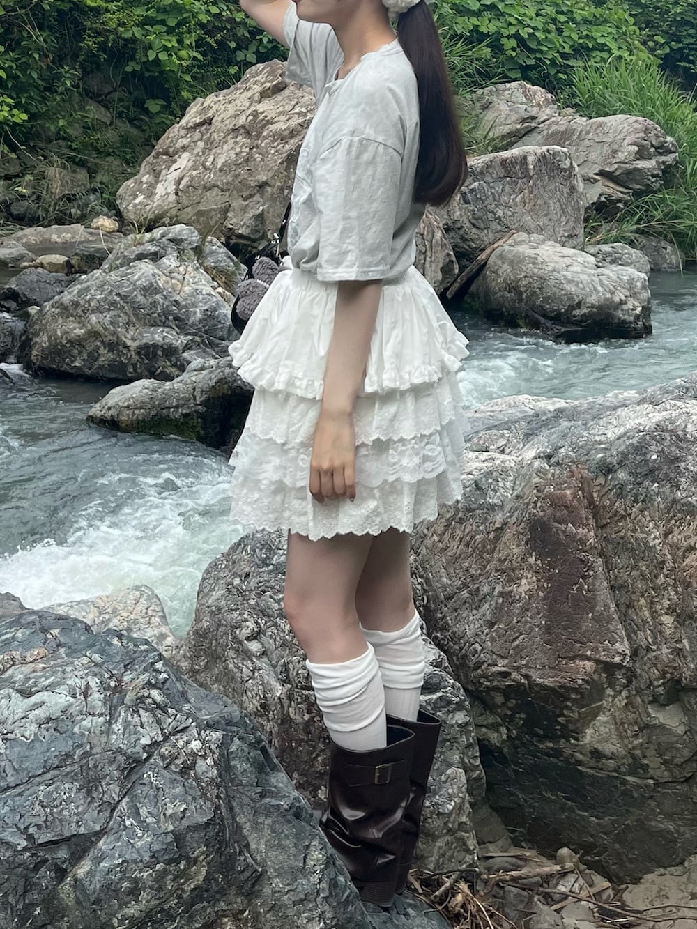 グレー系のTシャツ/カットソー、ブラウン系のブーツ、ホワイト系のスカートを着用したレディースの夏コーディネートの2枚目の写真