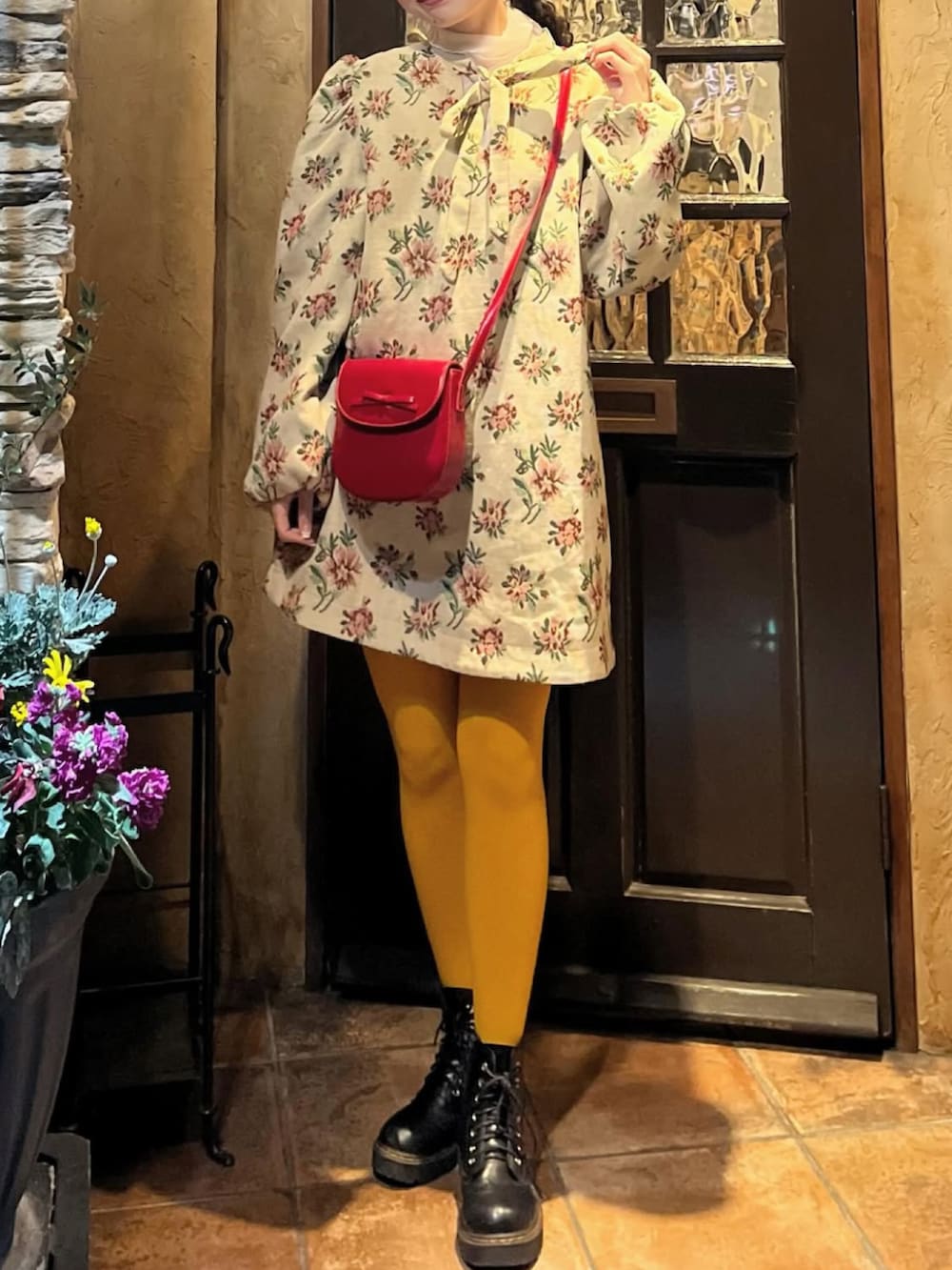 ブラック系のブーツ、ベージュ系のワンピース、イエロー系のタイツ/ストッキングを着用したレディースの春コーディネートの2枚目の写真