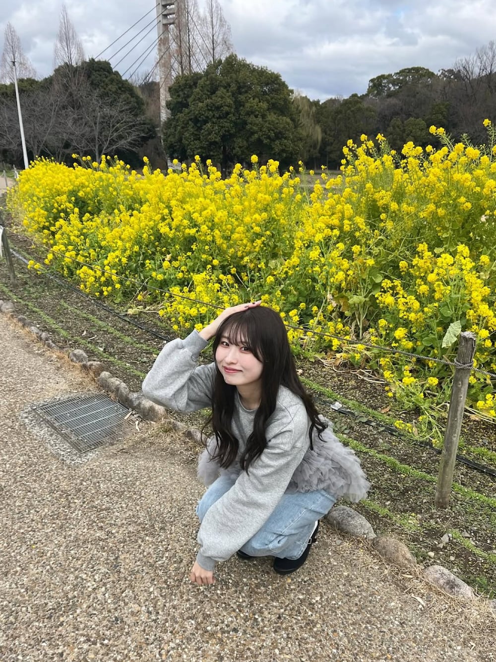 グレー系のスウェット、ブルー系のデニムパンツ、ブラック系のバレエシューズを着用したレディースの春コーディネートの4枚目の写真