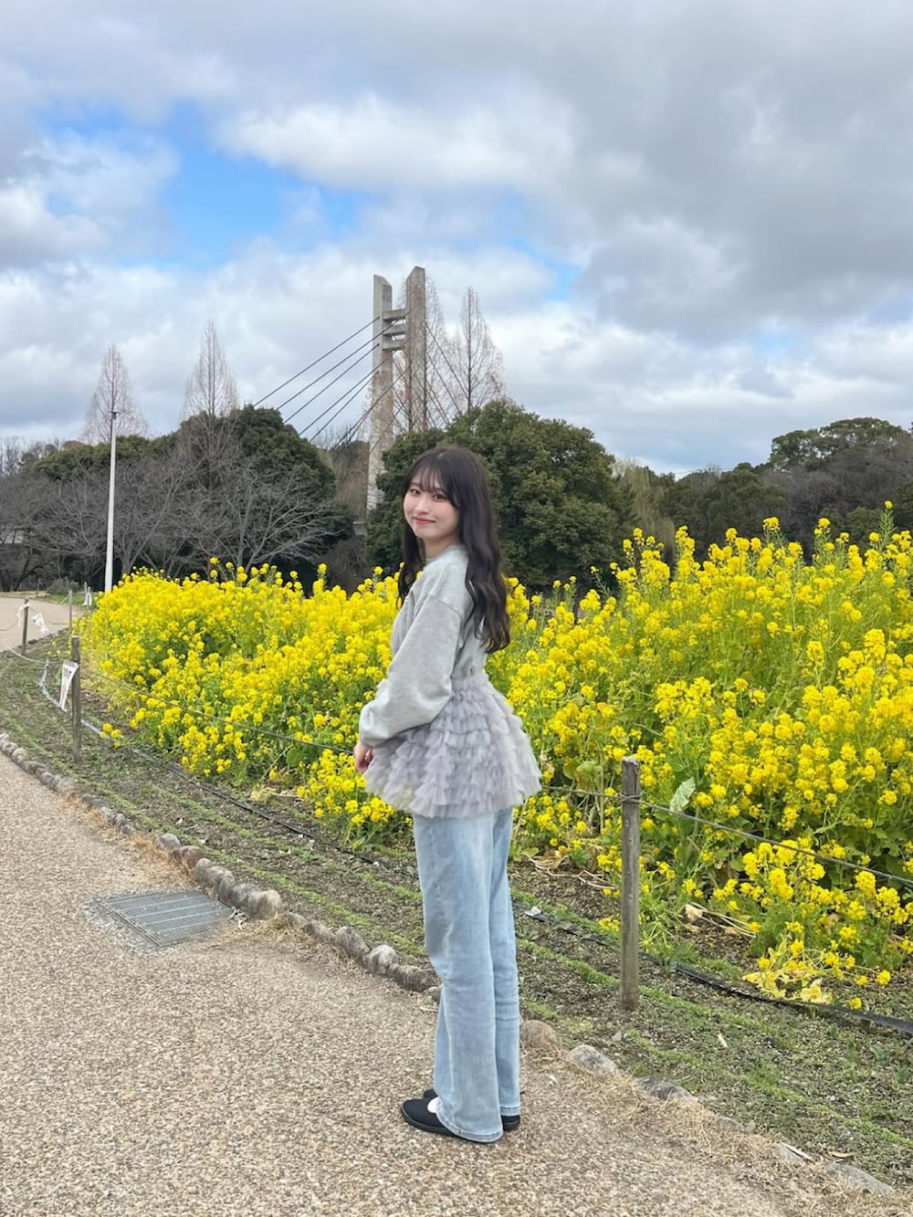 グレー系のスウェット、ブルー系のデニムパンツ、ブラック系のバレエシューズを着用したレディースの春コーディネートの5枚目の写真