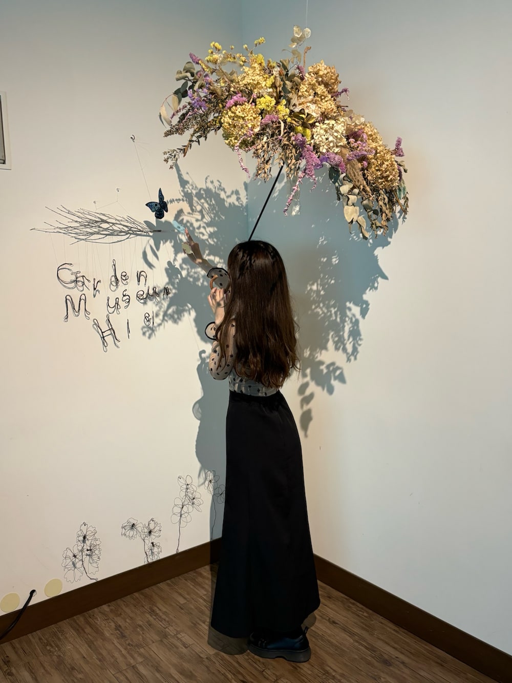 ベージュ系のTシャツ/カットソー、ブラック系のスカート、ブラック系のブーツを着用したレディースの夏コーディネートの3枚目の写真