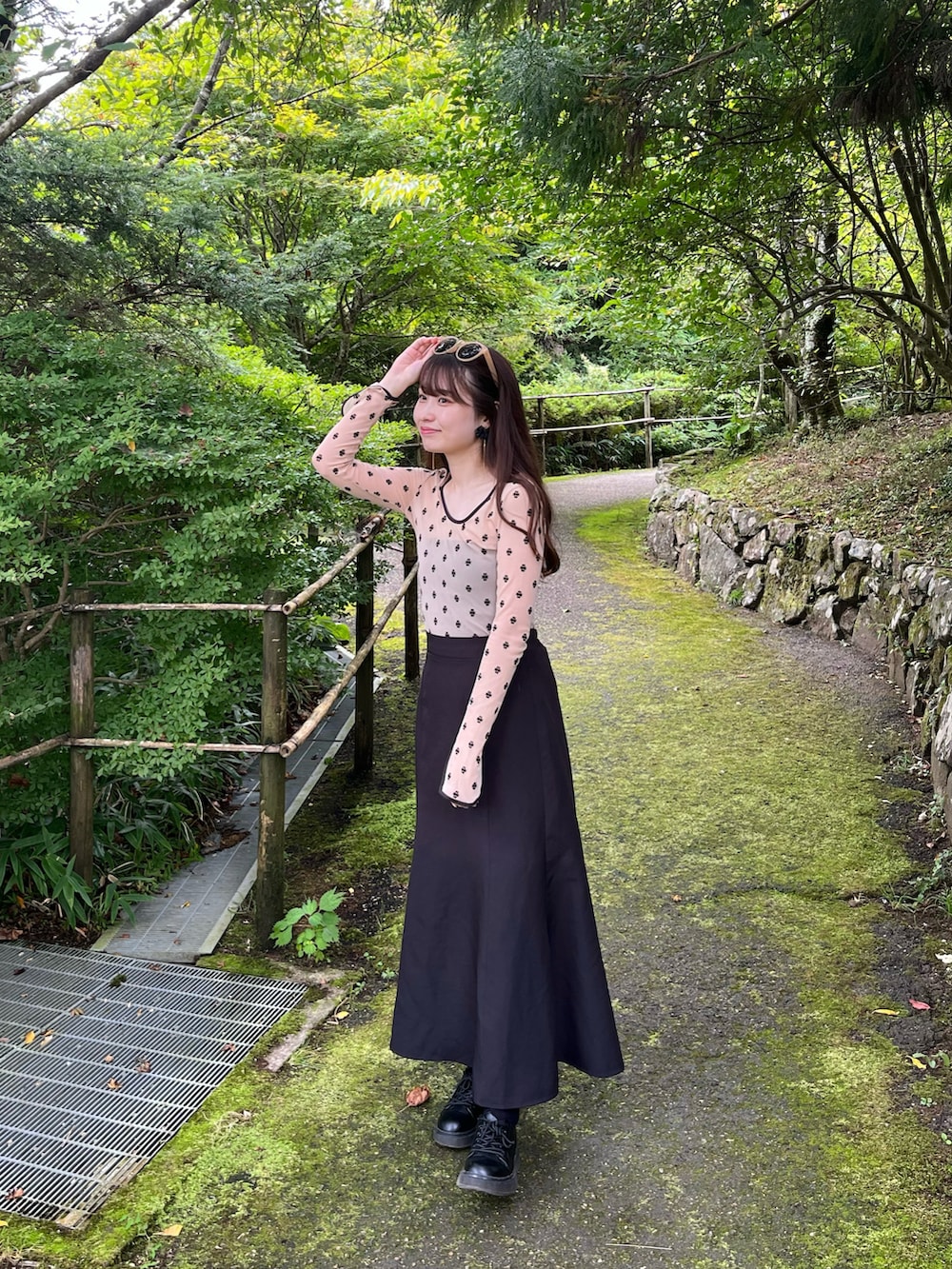 ベージュ系のTシャツ/カットソー、ブラック系のスカート、ブラック系のブーツを着用したレディースの夏コーディネートの2枚目の写真