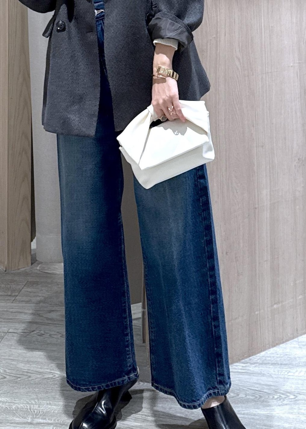 ブルー系のデニムパンツ、グレー系のテーラードジャケット、ホワイト系のショルダーバッグを着用したレディースの冬コーディネートの7枚目の写真