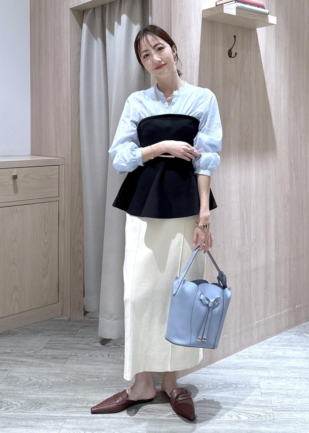 ブルー系のテーラードジャケット、ホワイト系のスカート、ブルー系のショルダーバッグを着用したレディースの春コーディネートの7枚目の写真
