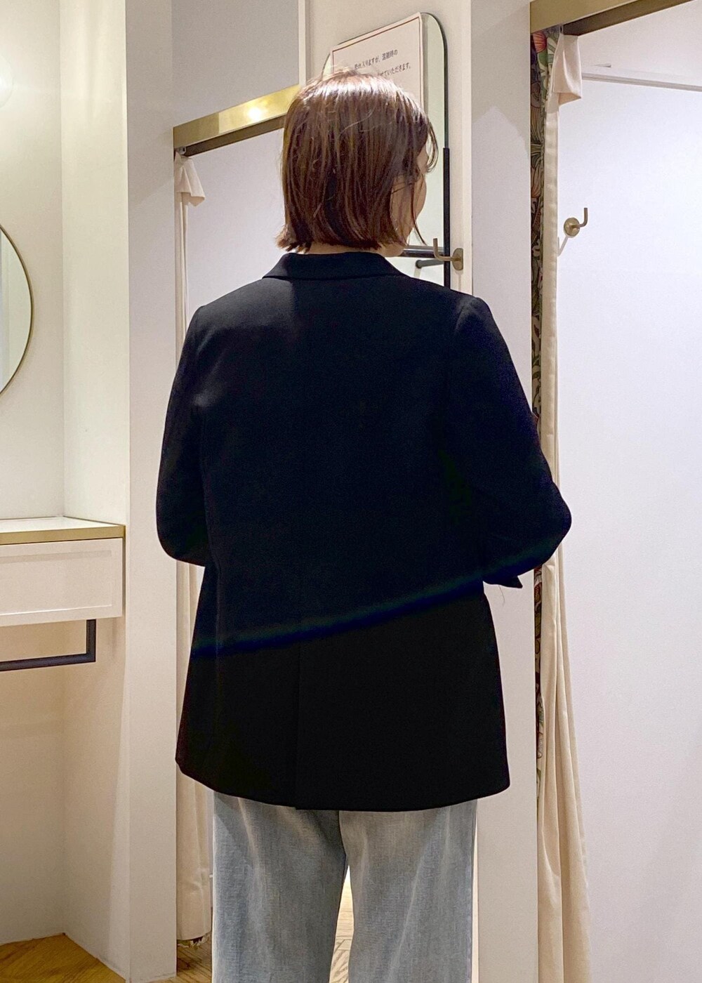 ブラック系のパンプス、グレー系のニット/セーター、ブルー系のデニムパンツを着用したレディースの冬コーディネートの7枚目の写真