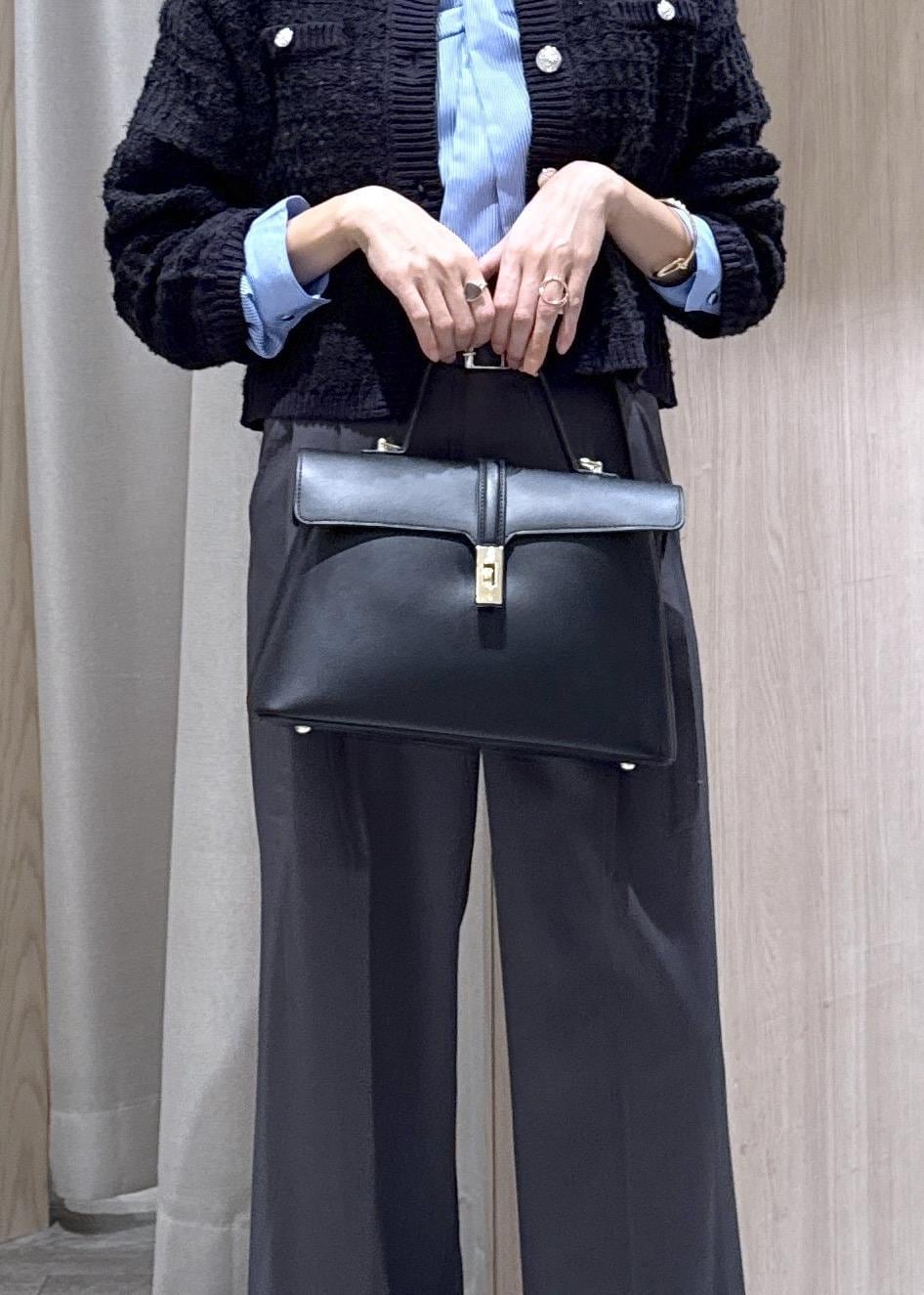 ブラック系のハンドバッグ、ブルー系のカーディガン/ボレロ、グレー系のその他パンツを着用したレディースの秋コーディネートの8枚目の写真