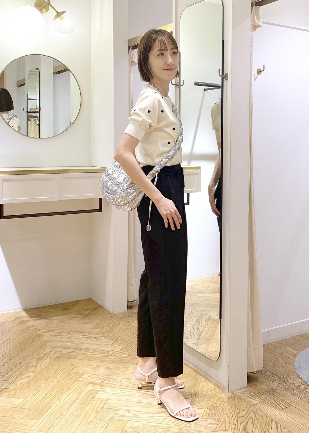 ホワイト系のサンダル、ホワイト系のキャミソール、ホワイト系のニット/セーターを着用したレディースの春コーディネートの2枚目の写真