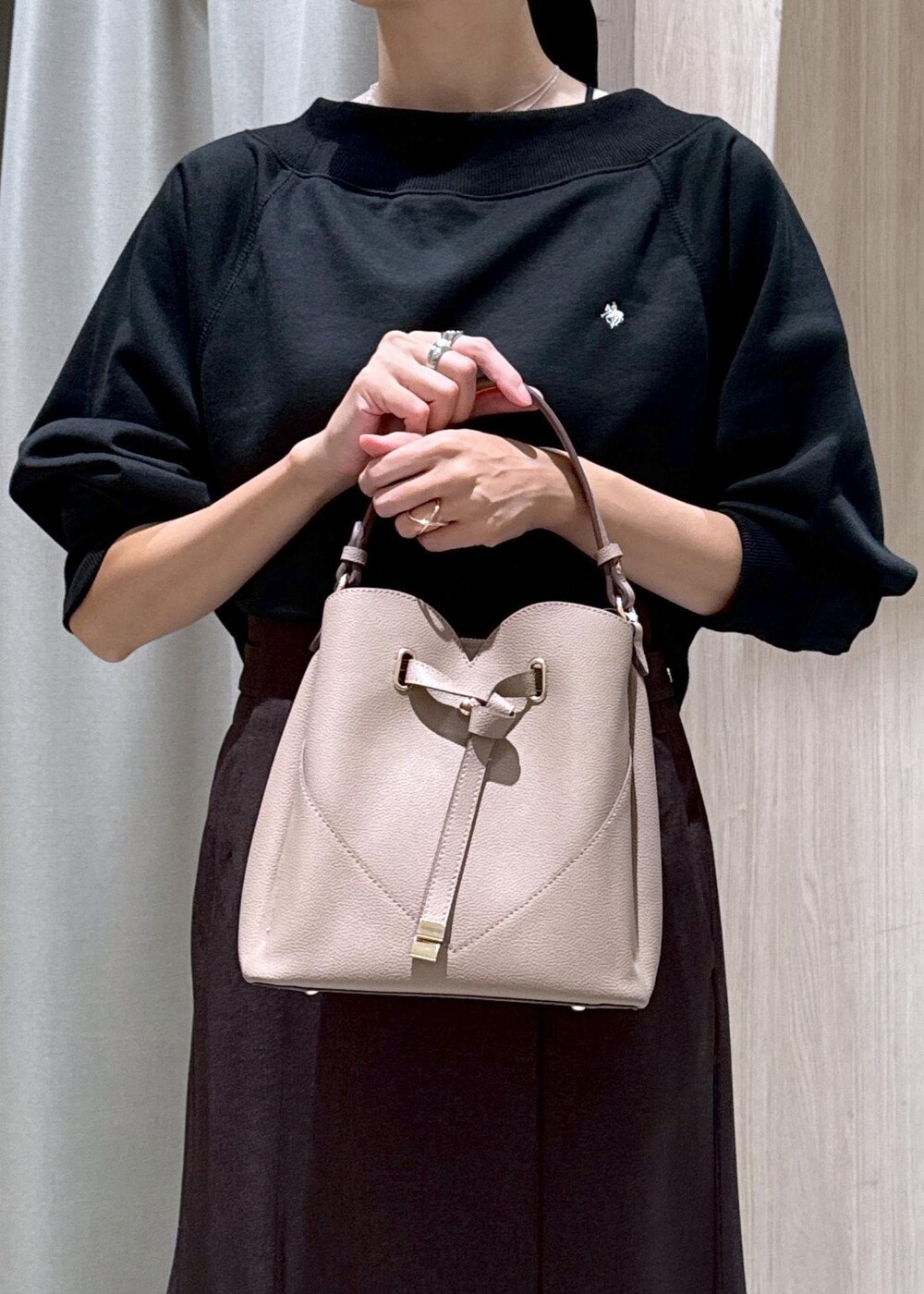 ブラック系のキャミソール、ブラウン系のスカート、ブラック系のブーツを着用したレディースの秋コーディネートの9枚目の写真