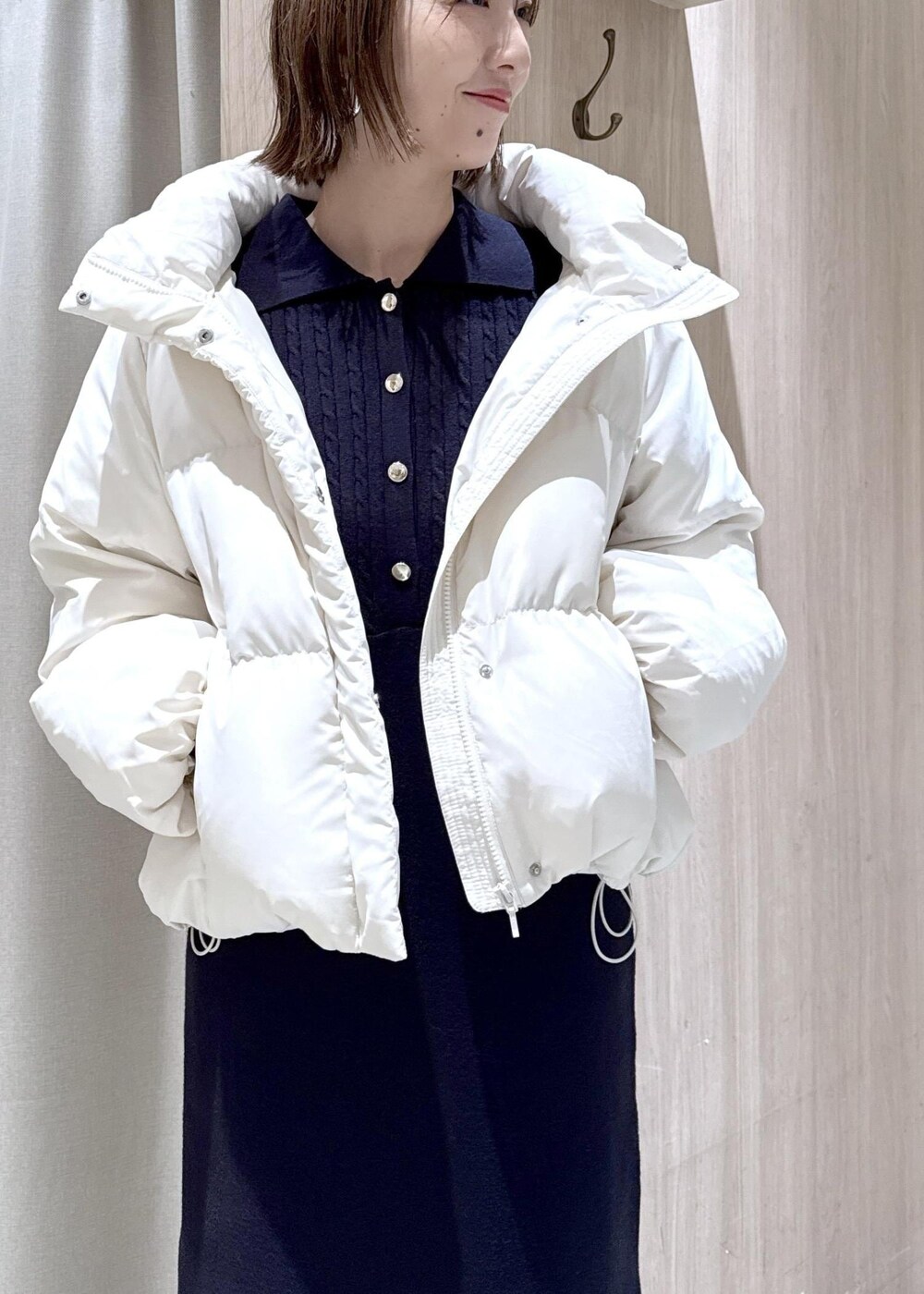 ホワイト系のダウンジャケット/コート、ブルー系のデニムパンツ、ブルー系のワンピースを着用したレディースの冬コーディネートの6枚目の写真