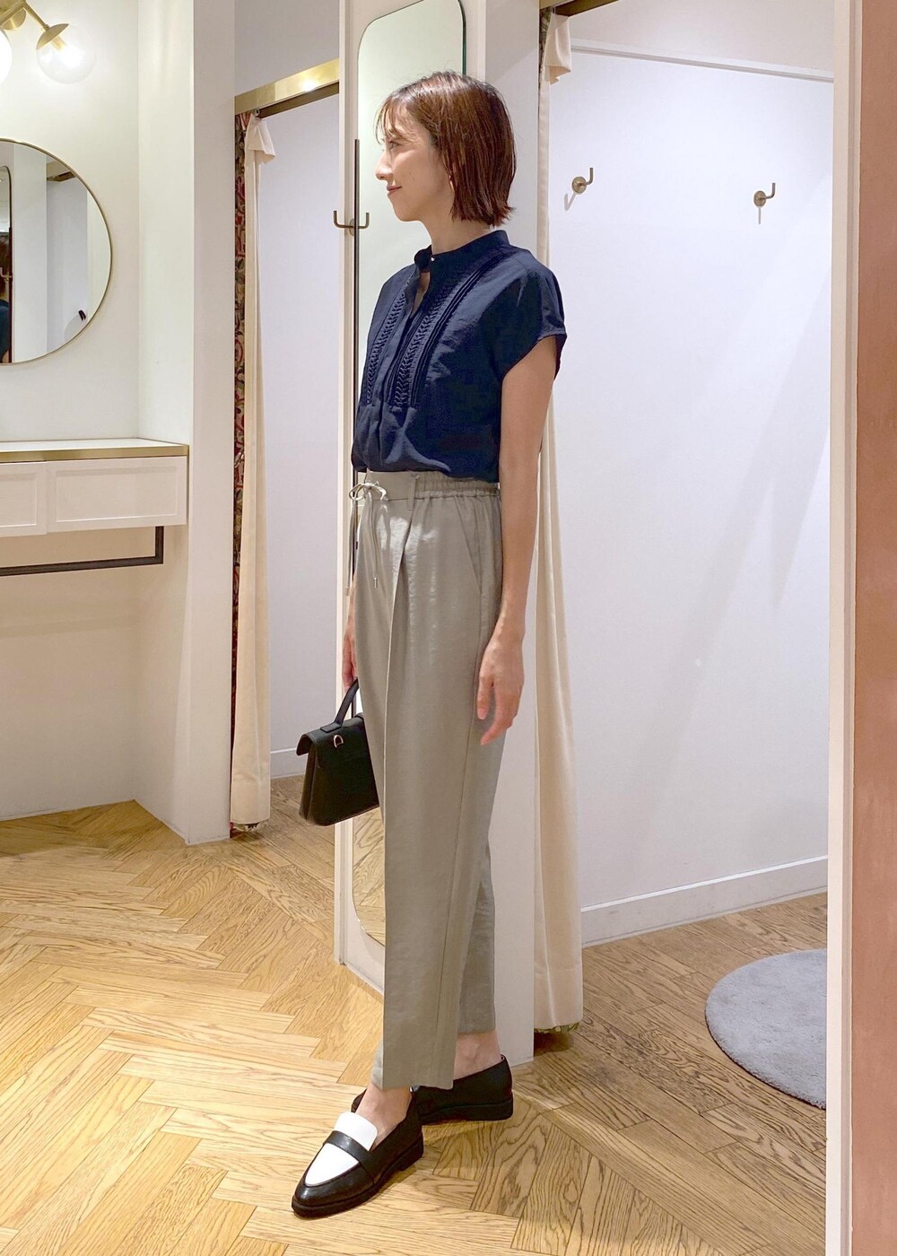 ブラック系のキャミソール、ブラック系のローファー、ブラック系のショルダーバッグを着用したレディースの夏コーディネートの3枚目の写真