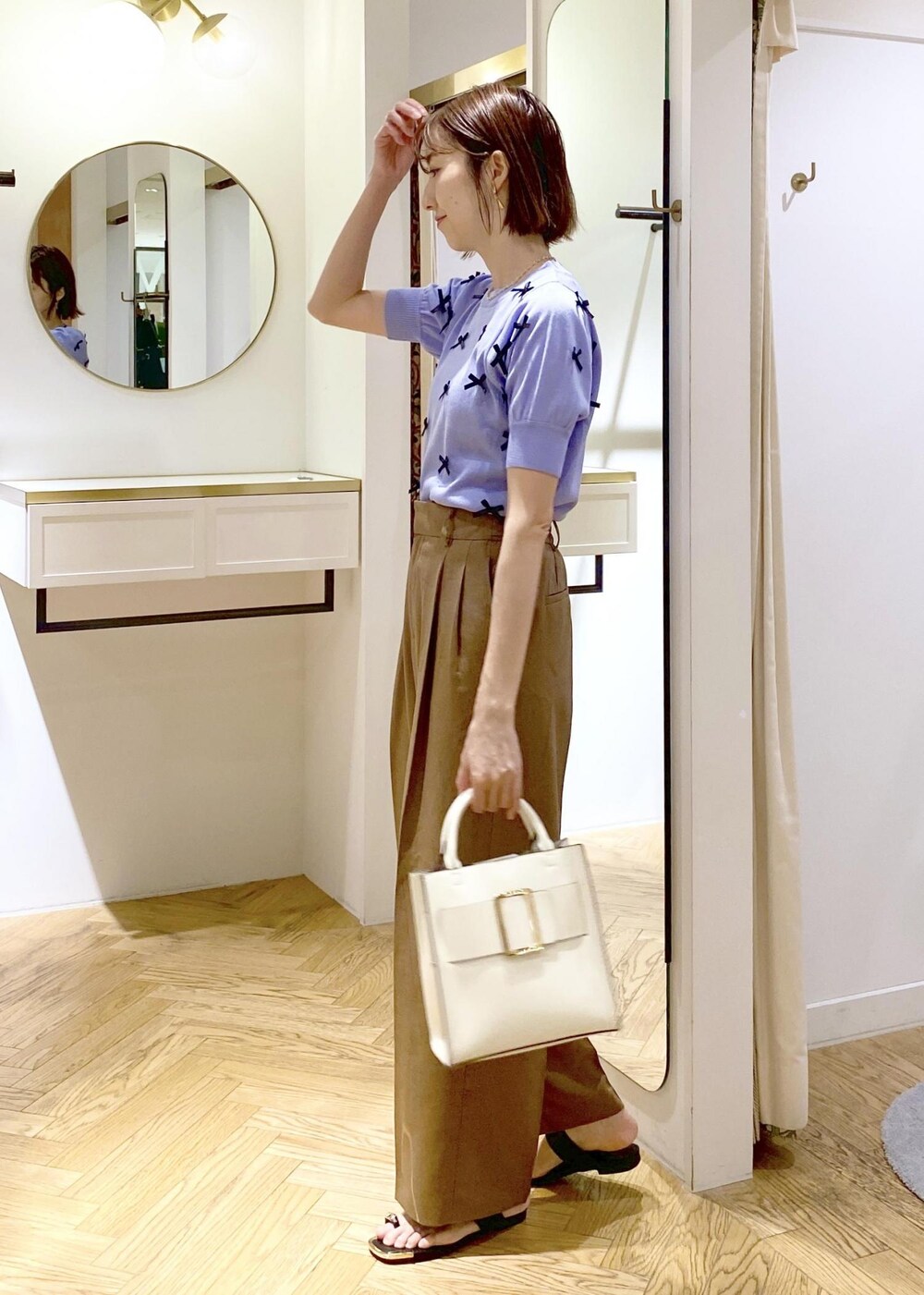 ブラック系のキャミソール、ブラック系のサンダル、ホワイト系のハンドバッグを着用したレディースの春コーディネートの2枚目の写真