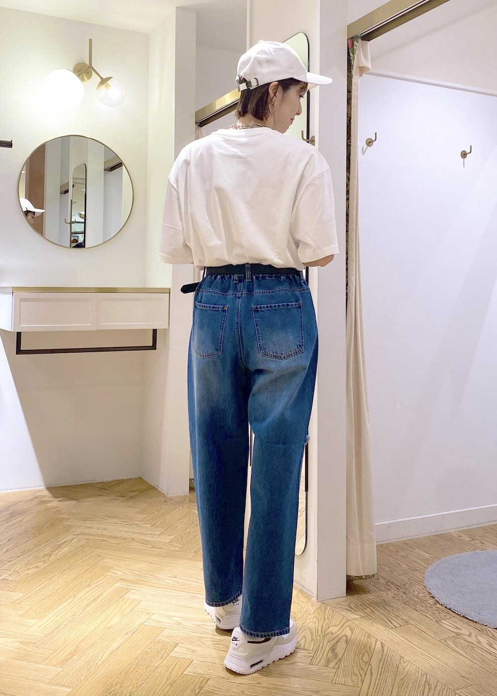 ブルー系のデニムパンツ、ブラック系のショルダーバッグ、ホワイト系のTシャツ/カットソーを着用したレディースの春コーディネートの3枚目の写真