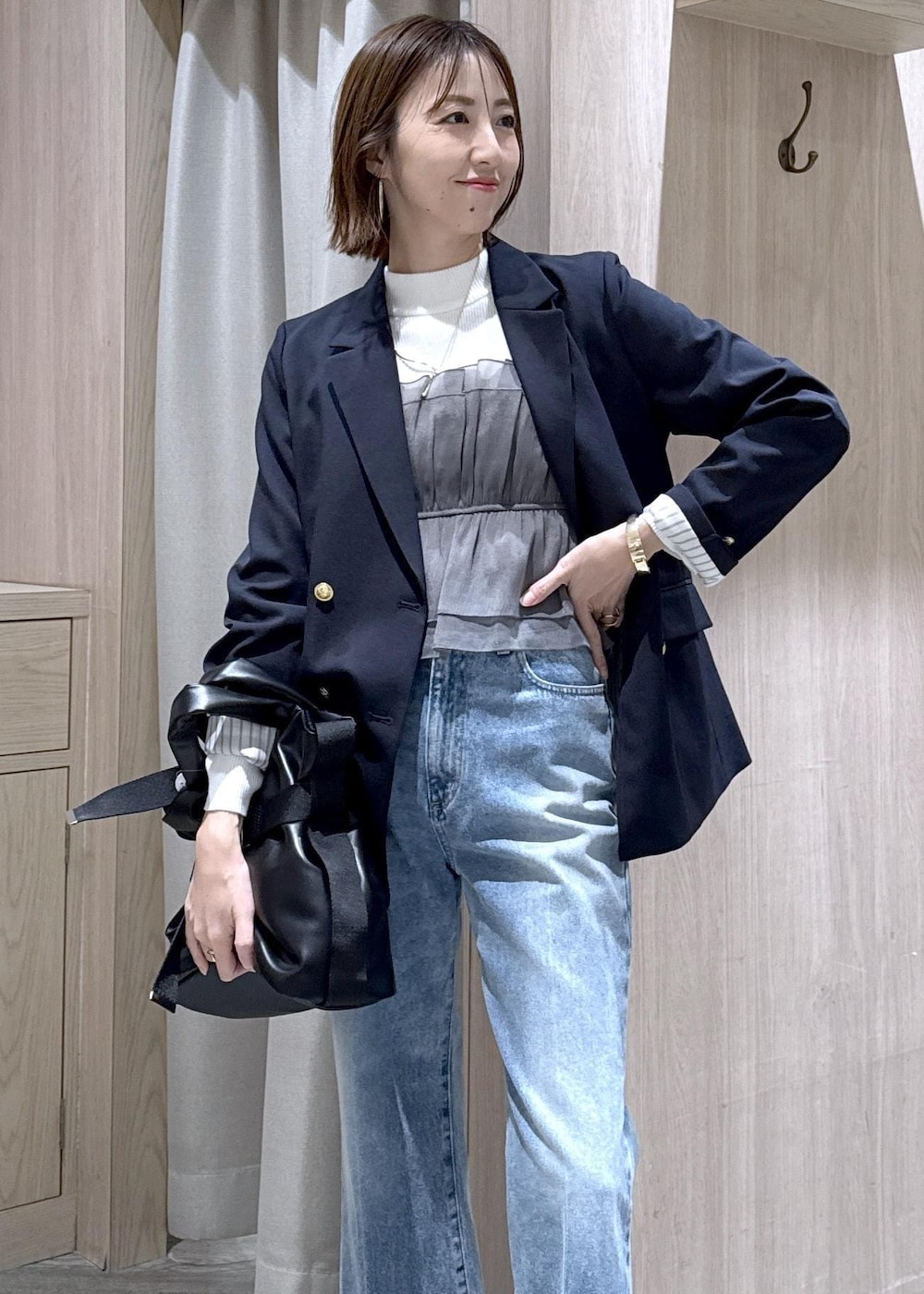 ホワイト系のニット/セーター、ブルー系のテーラードジャケット、ブルー系のデニムパンツを着用したレディースの冬コーディネートの4枚目の写真