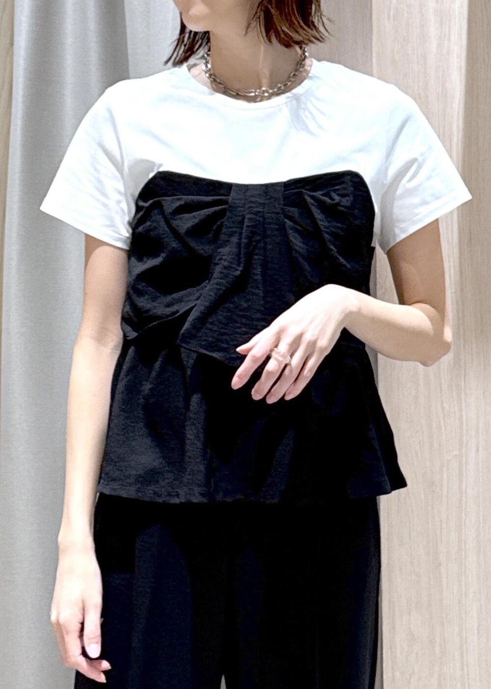 ベージュ系のショルダーバッグ、ブラック系のパンプス、ホワイト系のテーラードジャケットを着用したレディースの春コーディネートの8枚目の写真