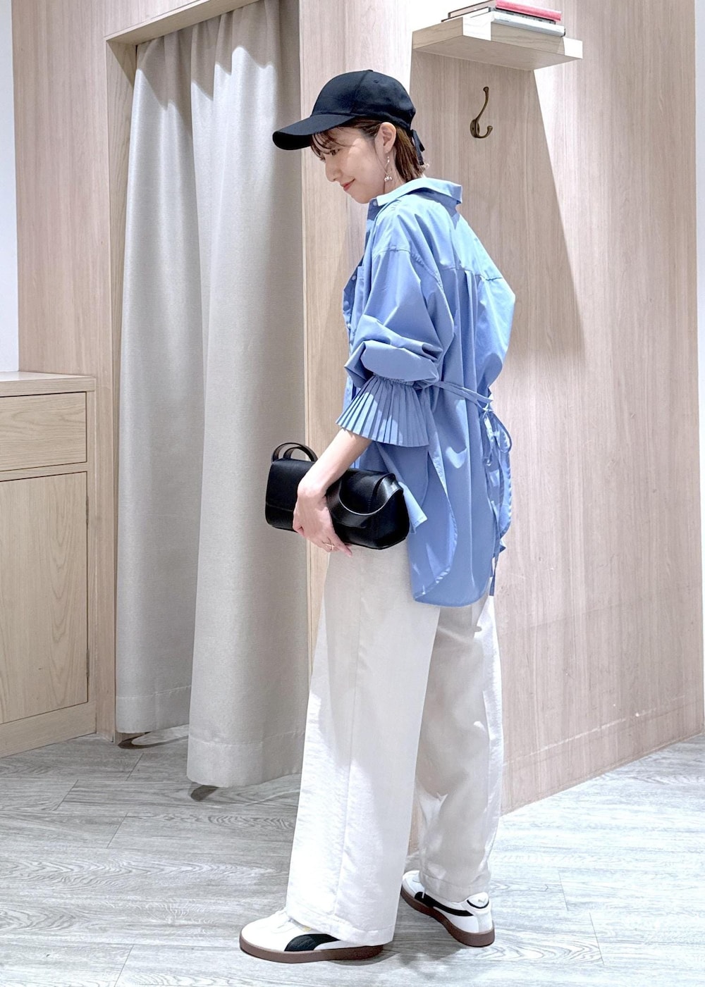 グレー系のタンクトップ、ブルー系のシャツ/ブラウス、ブラック系のショルダーバッグを着用したレディースの春コーディネートの4枚目の写真