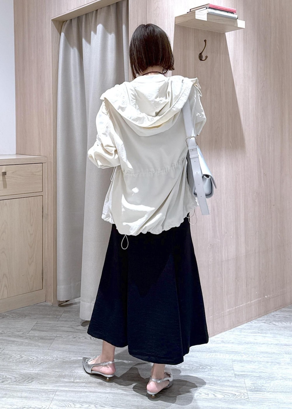 シルバー系のパンプス、ブラック系のスカート、ホワイト系のカーディガン/ボレロを着用したレディースの春コーディネートの5枚目の写真