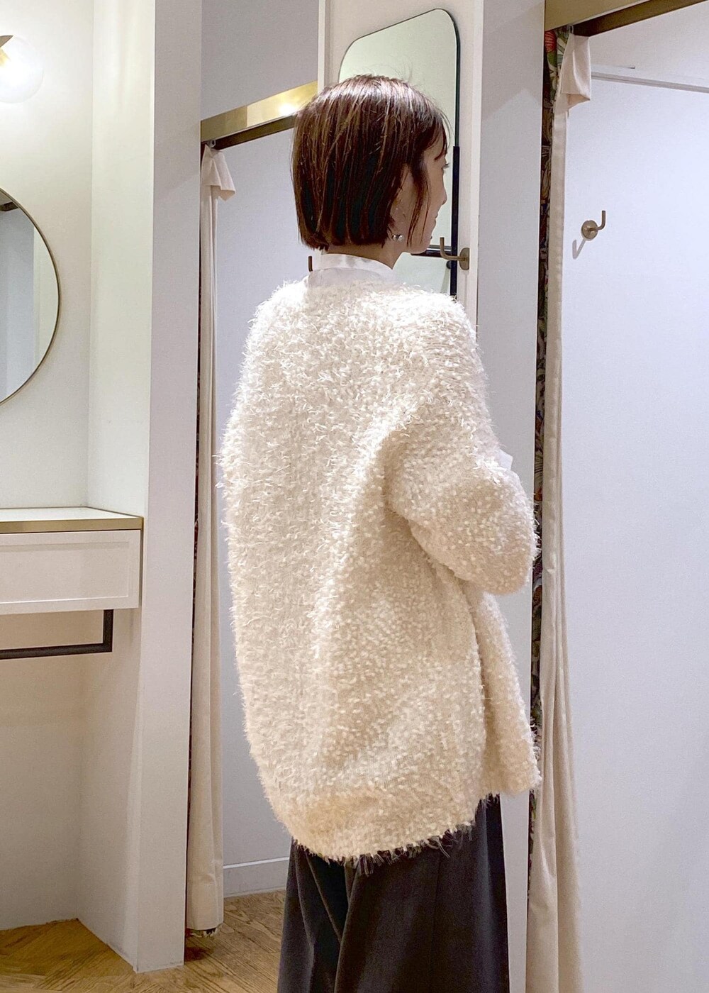 ブラック系のブーツ、ホワイト系のカーディガン/ボレロ、ホワイト系のシャツ/ブラウスを着用したレディースの冬コーディネートの8枚目の写真