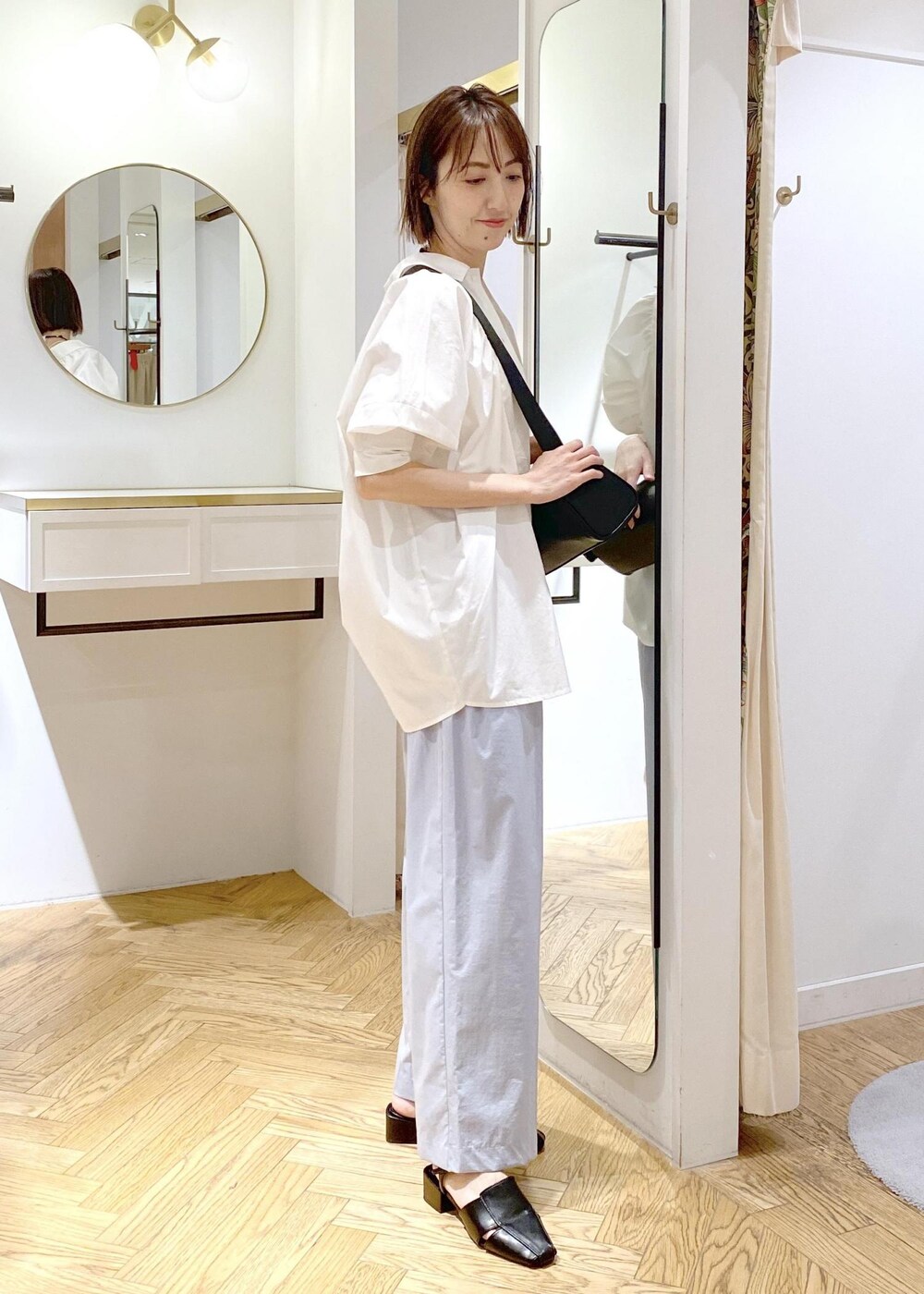 ブラック系のサンダル、ホワイト系のキャミソール、ホワイト系のシャツ/ブラウスを着用したレディースの春コーディネートの2枚目の写真