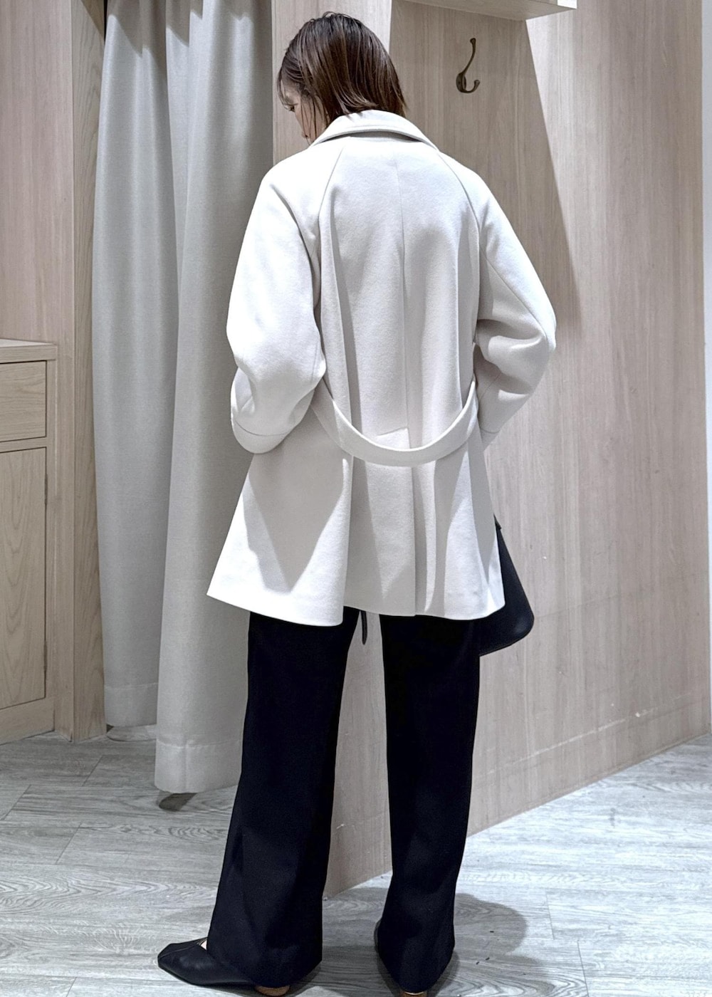 ブラック系のスラックス、ブラック系のショルダーバッグ、ブルー系のニット/セーターを着用したレディースの秋コーディネートの10枚目の写真