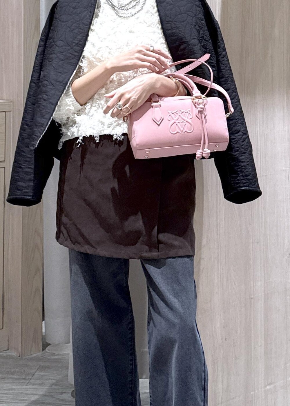 ピンク系のボストンバッグ、ブラック系のブーツ、ブラック系のブルゾンを着用したレディースの秋コーディネートの3枚目の写真