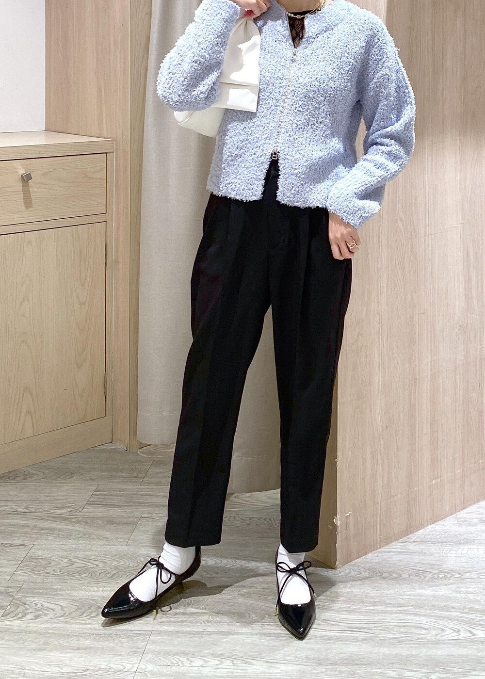 ブラック系のパンプス、ブルー系のカーディガン/ボレロ、ブラック系のTシャツ/カットソーを着用したレディースの冬コーディネートの6枚目の写真