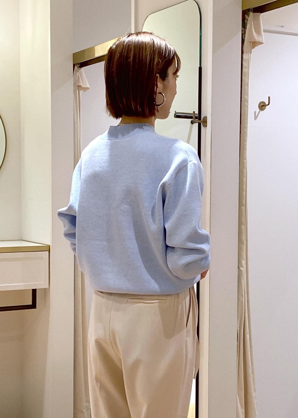 ホワイト系のブーツ、ブルー系のニット/セーター、ベージュ系のその他パンツを着用したレディースの冬コーディネートの8枚目の写真