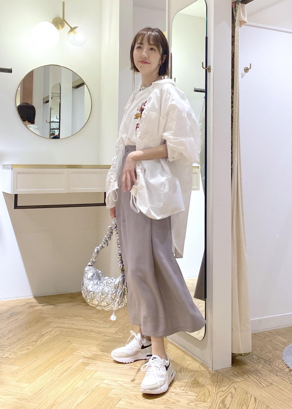 グレー系のスカート、ホワイト系のブルゾン、ホワイト系のTシャツ/カットソーを着用したレディースの春コーディネートの4枚目の写真