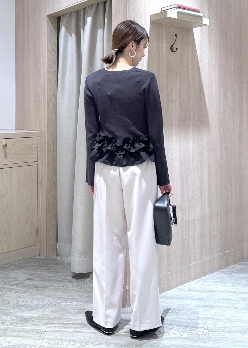 ブラック系のショルダーバッグ、ブラック系のパンプス、グレー系のニット/セーターを着用したレディースの春コーディネートの2枚目の写真