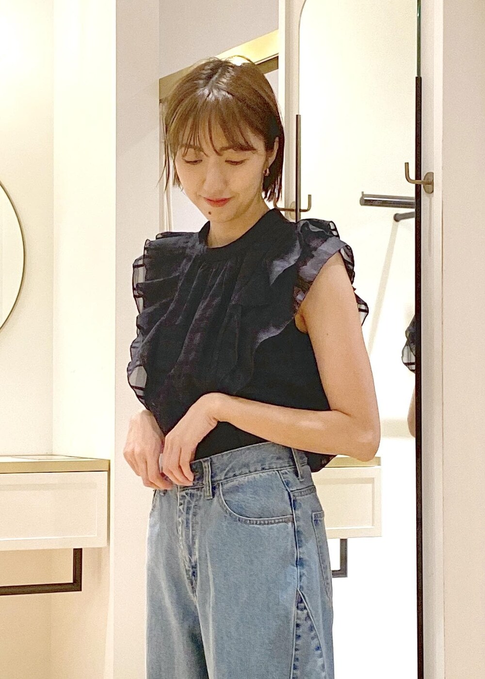 シルバー系のパンプス、ブルー系のデニムパンツ、ブルー系のシャツ/ブラウスを着用したレディースの夏コーディネートの4枚目の写真