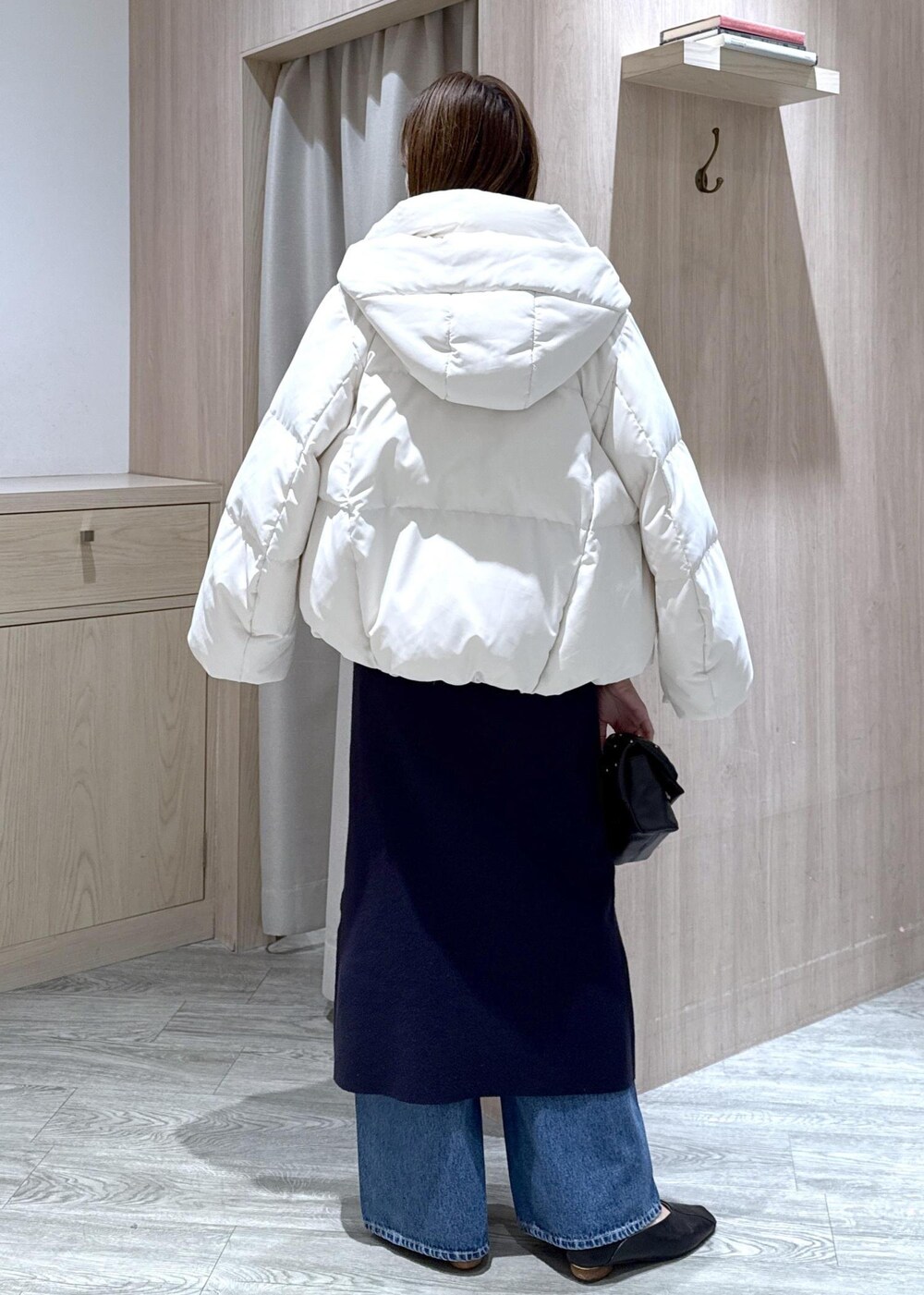 ホワイト系のダウンジャケット/コート、ブルー系のデニムパンツ、ブルー系のワンピースを着用したレディースの冬コーディネートの3枚目の写真