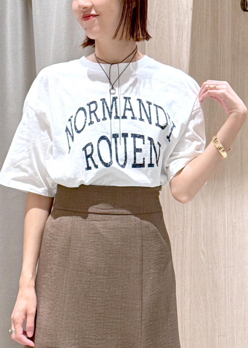 グリーン系のスカート、ホワイト系のTシャツ/カットソー、ブラック系のハンドバッグを着用したレディースの春コーディネートの9枚目の写真