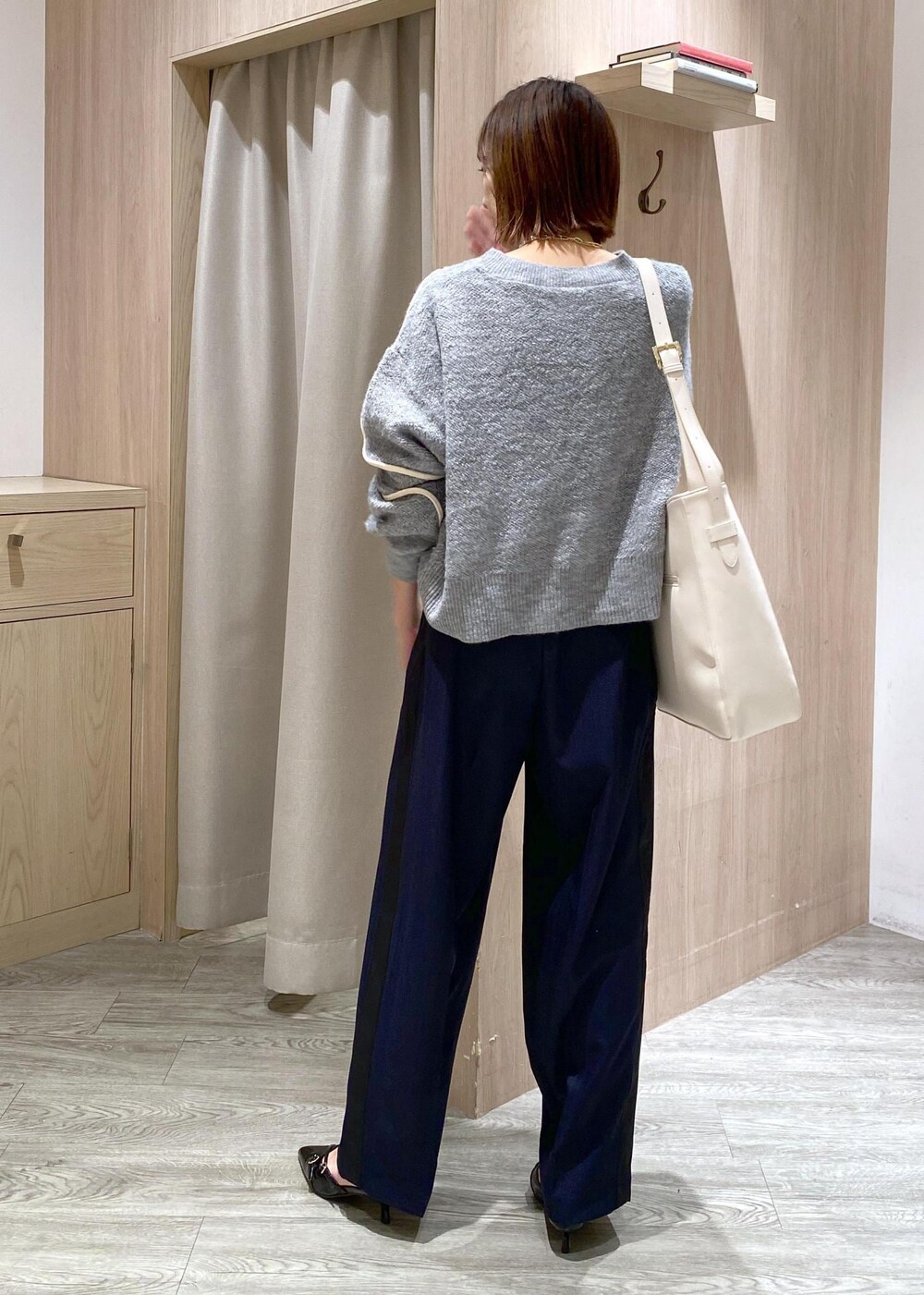 ブラック系のパンプス、グレー系のニット/セーター、ホワイト系のトートバッグを着用したレディースの冬コーディネートの2枚目の写真