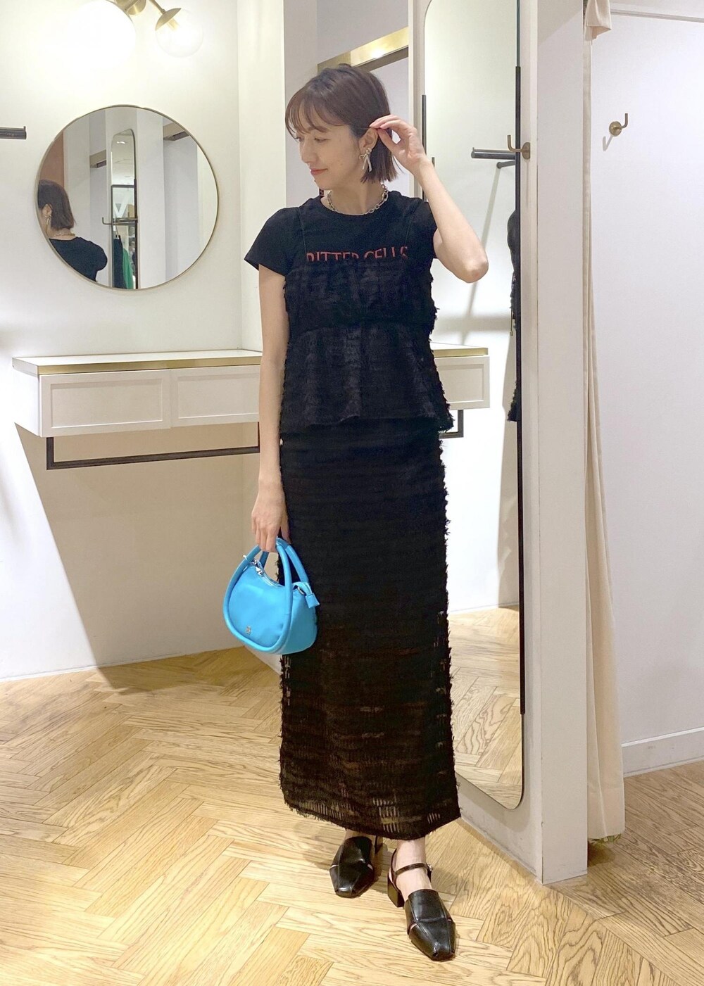 ブラック系のサンダル、ブラック系のスカート、ブラック系のキャミソールを着用したレディースの春コーディネートの4枚目の写真