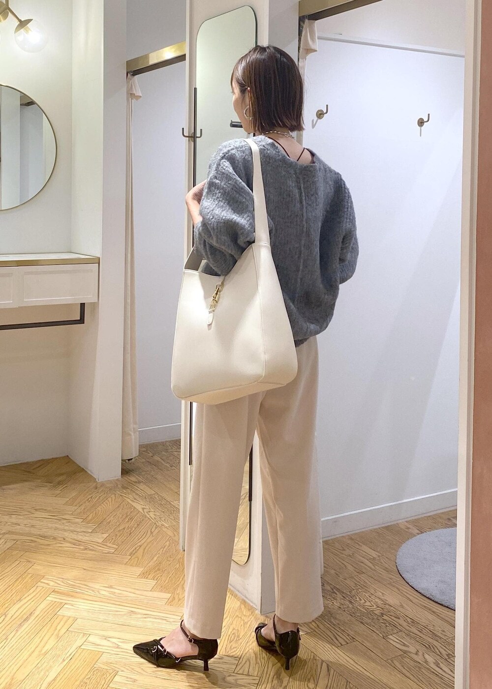 ホワイト系のトートバッグ、ブラック系のパンプス、ベージュ系のその他パンツを着用したレディースの冬コーディネートの5枚目の写真