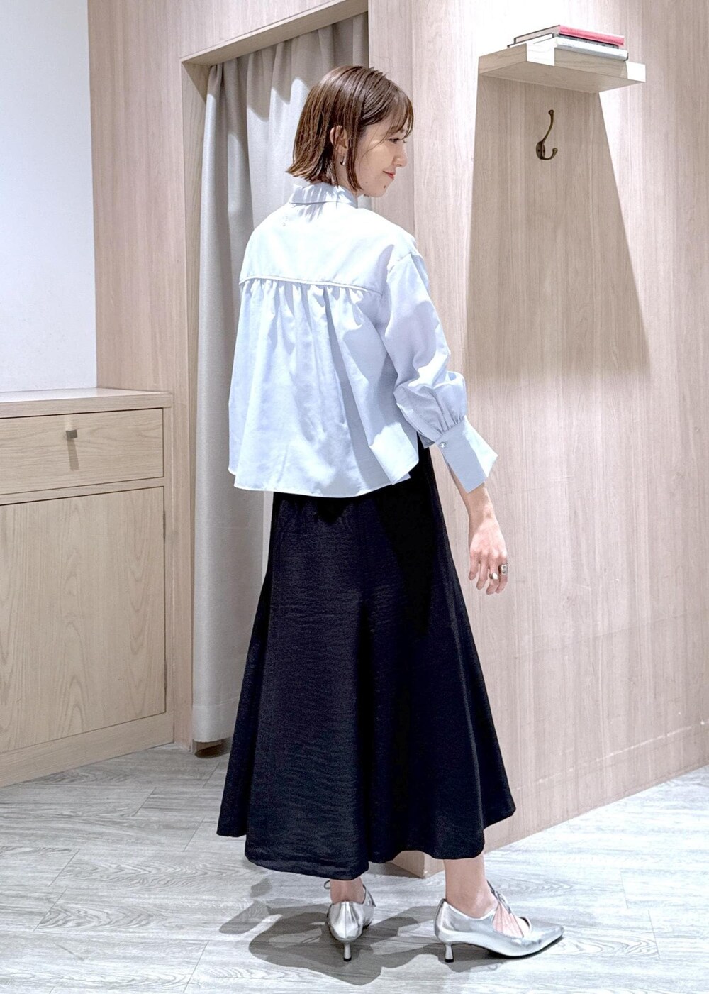 ホワイト系のショルダーバッグ、シルバー系のパンプス、ブラック系のスカートを着用したレディースの春コーディネートの3枚目の写真