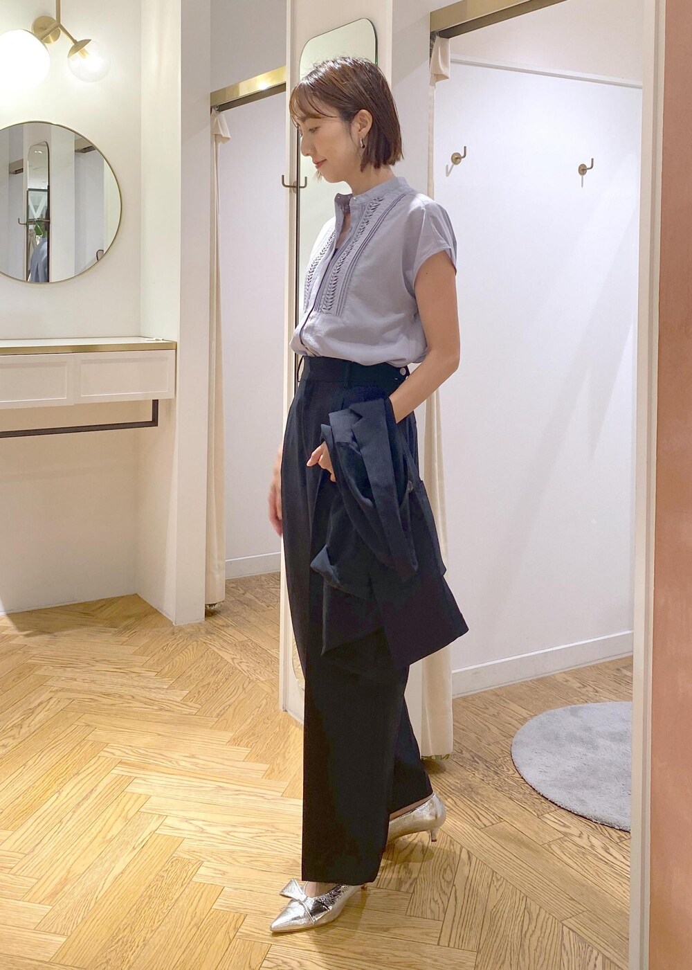 シルバー系のパンプス、ブルー系のスラックス、ブルー系のテーラードジャケットを着用したレディースの夏コーディネートの6枚目の写真